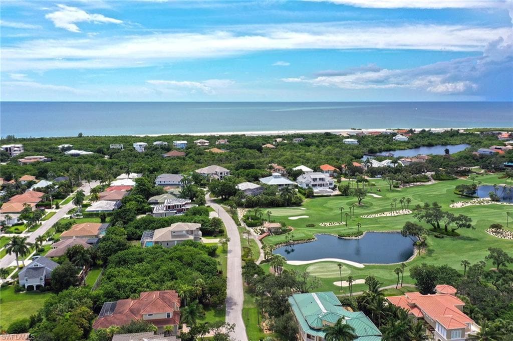 Aerial view of residential area with a nearby body of water and a golf club