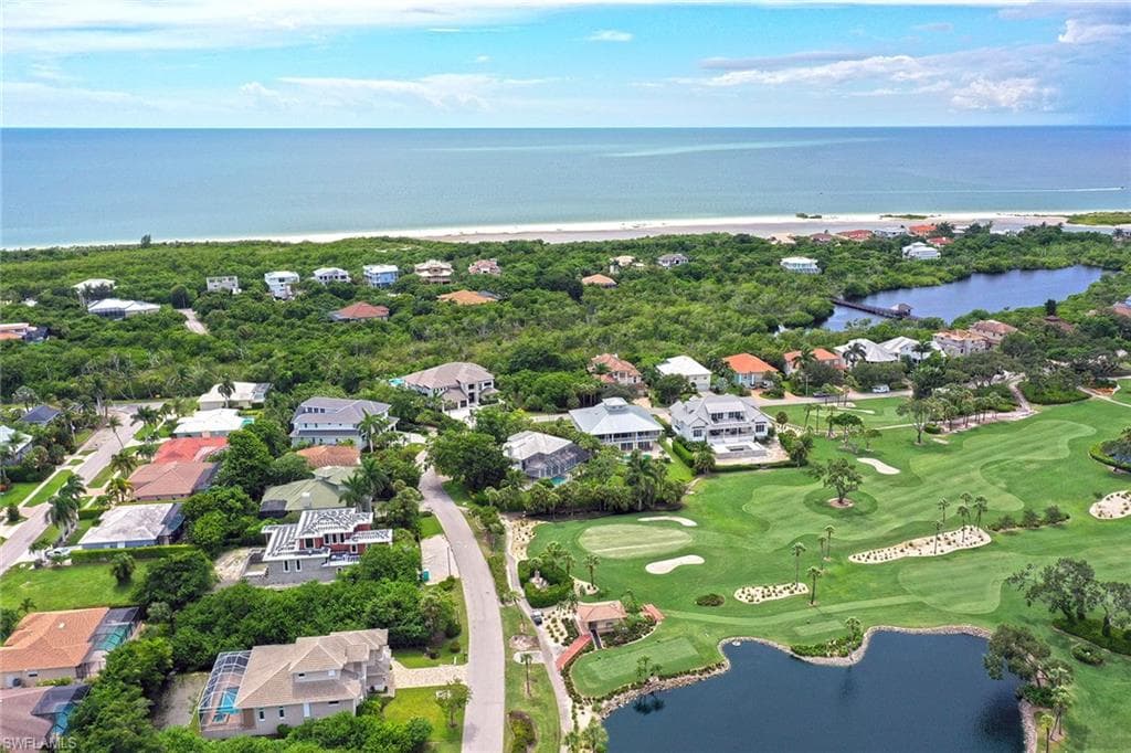 View of property location with a nearby body of water, nearby suburban area, and a golf course