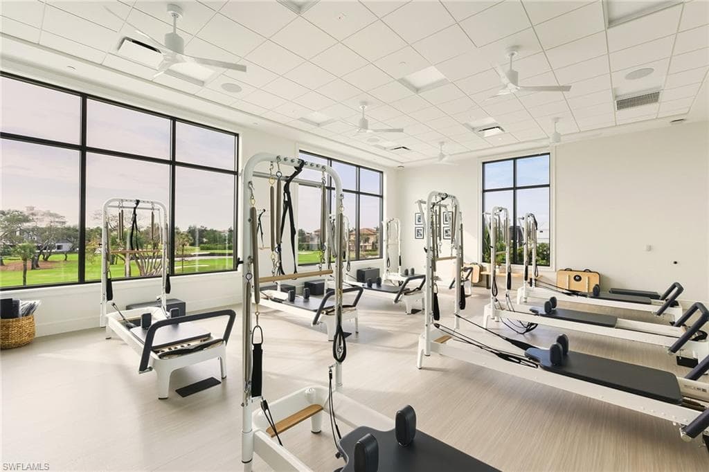 Exercise room featuring a ceiling fan and a paneled ceiling
