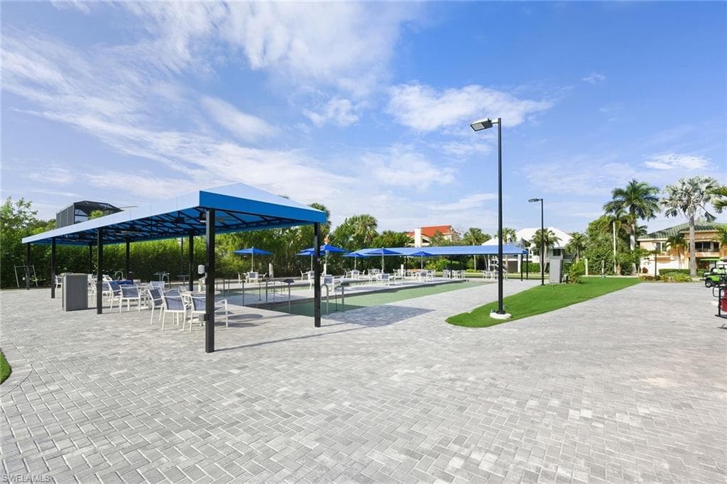 View of home's community with a bocce ball area and a patio area