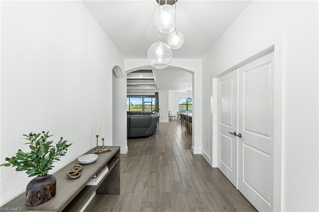 Hall with wood finished floors and arched walkways