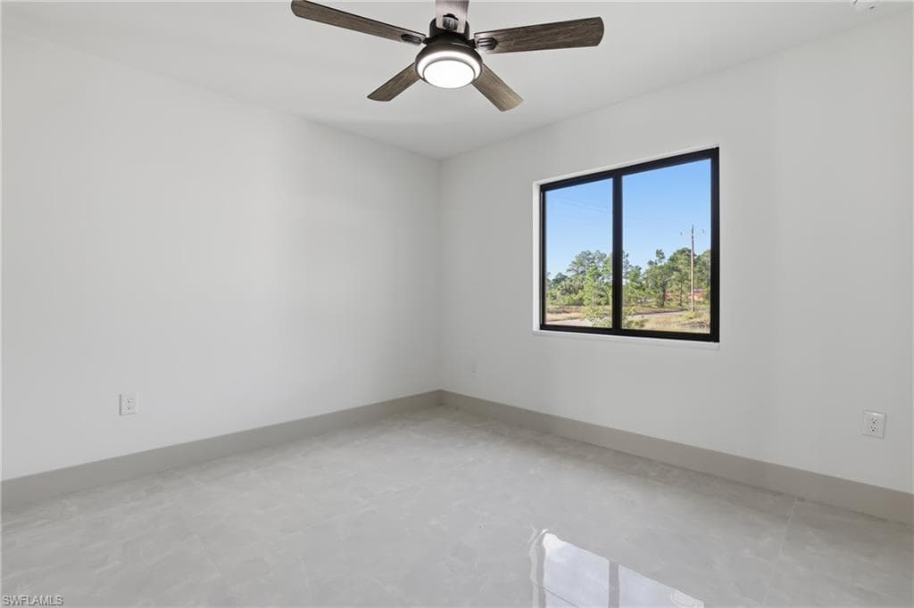 Spare room with baseboards and ceiling fan