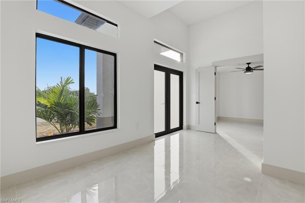 Entryway featuring a high ceiling, french doors, plenty of natural light, and a ceiling fan
