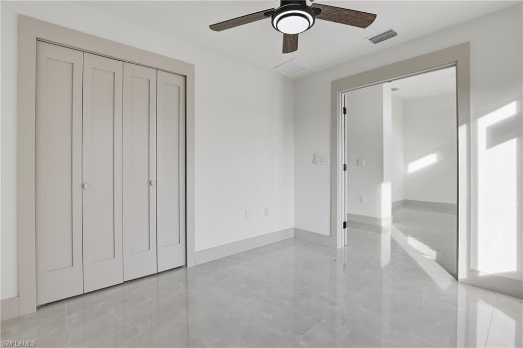 Unfurnished bedroom featuring a ceiling fan and a closet