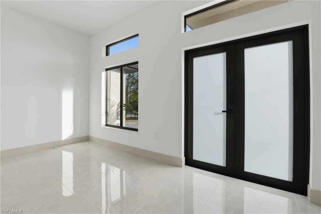 Spare room with french doors and baseboards