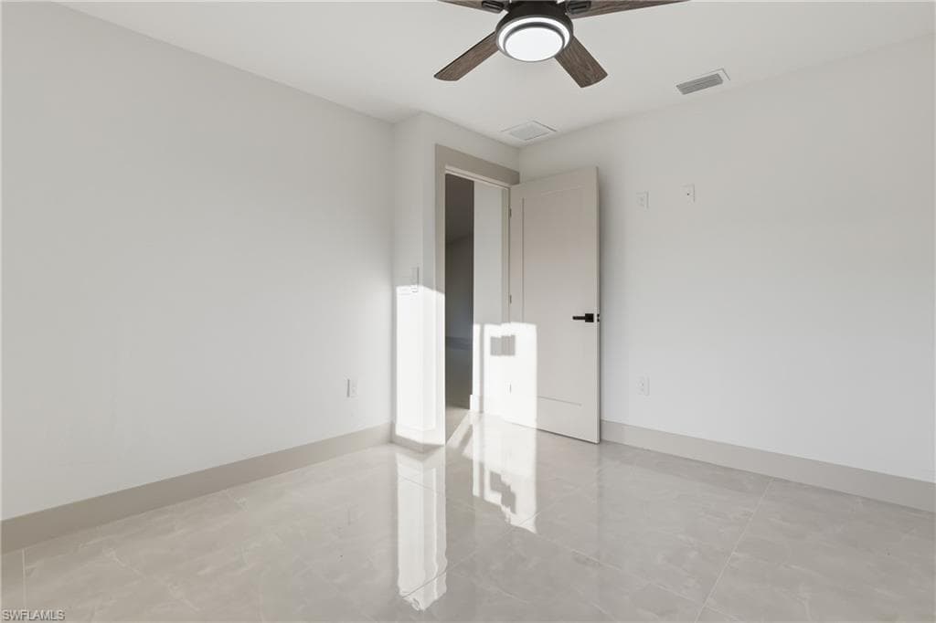 Unfurnished room with baseboards and a ceiling fan