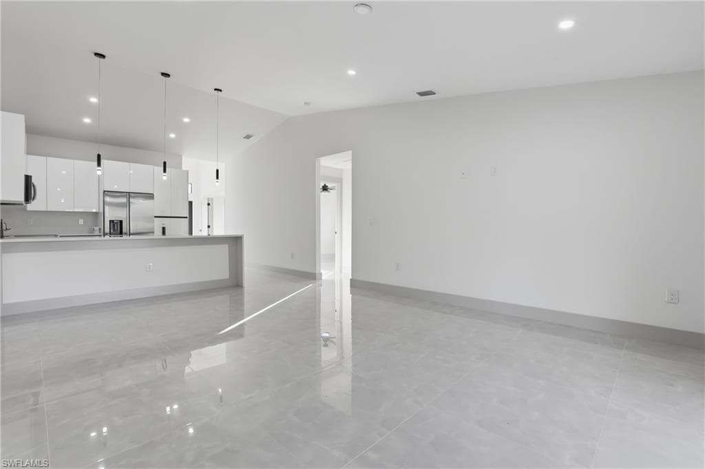 Unfurnished living room with recessed lighting and lofted ceiling
