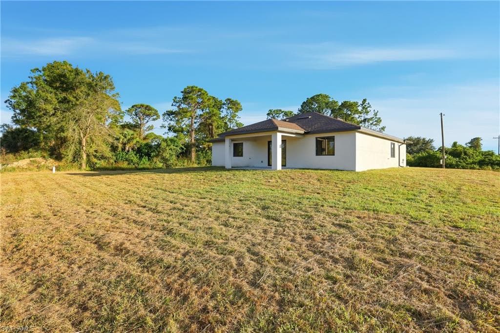 View of grassy yard featuring a patio