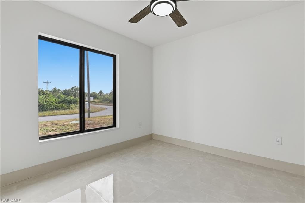 Empty room featuring baseboards and ceiling fan