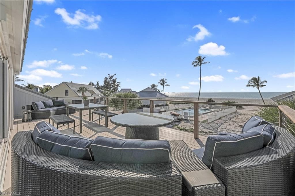 View of patio with an outdoor hangout area and a deck with water view