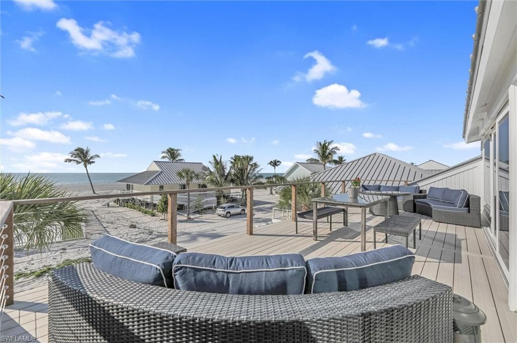 Wooden terrace with an outdoor hangout area and a water view