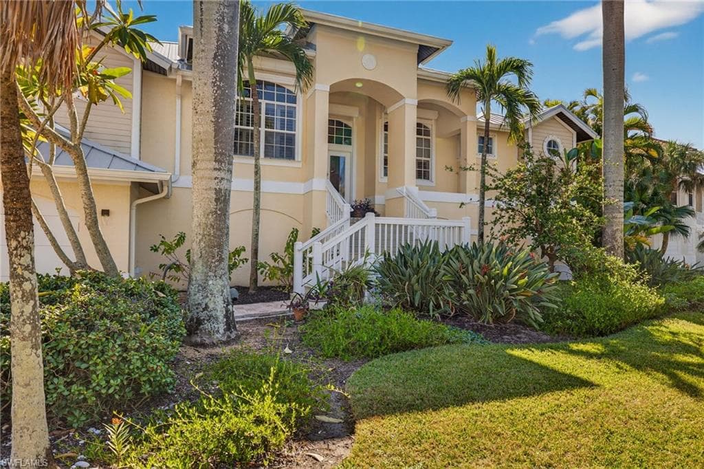 Mediterranean / spanish house featuring stucco siding, a front lawn, and covered porch