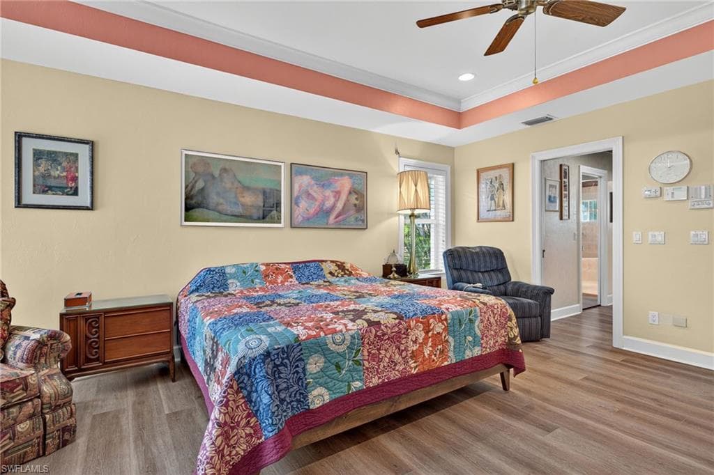 Bedroom featuring wood finished floors, crown molding, ceiling fan, and recessed lighting