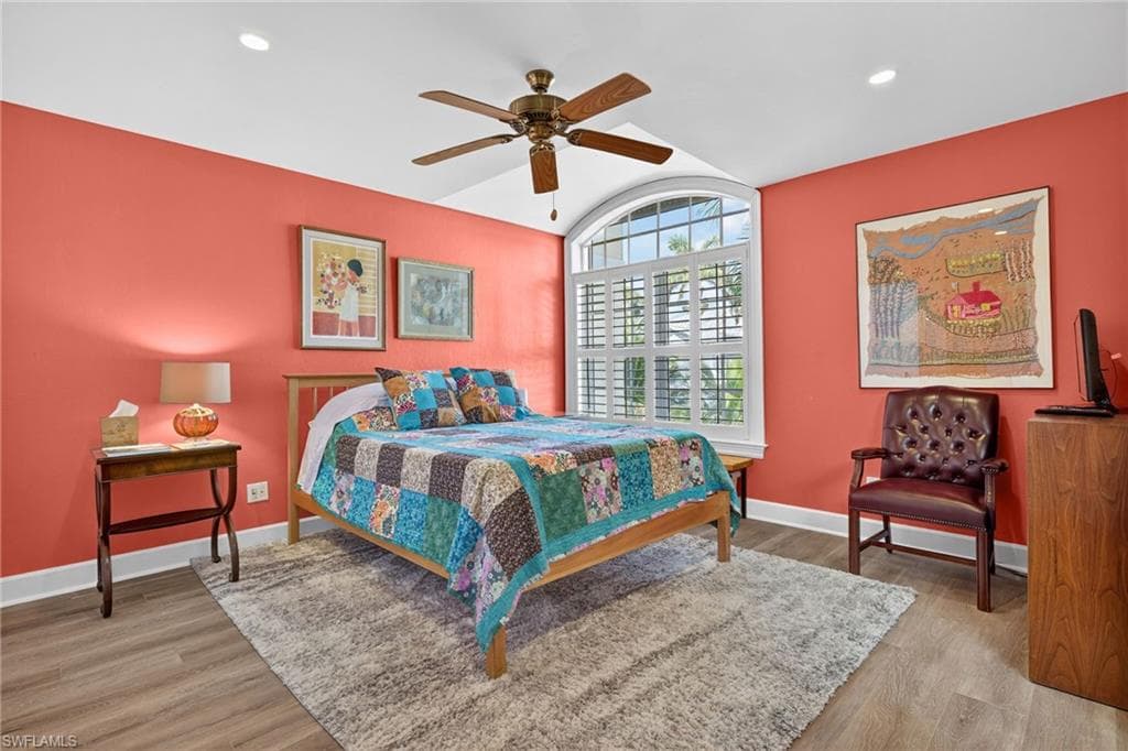 Bedroom with light wood-type flooring, a ceiling fan, lofted ceiling, and recessed lighting