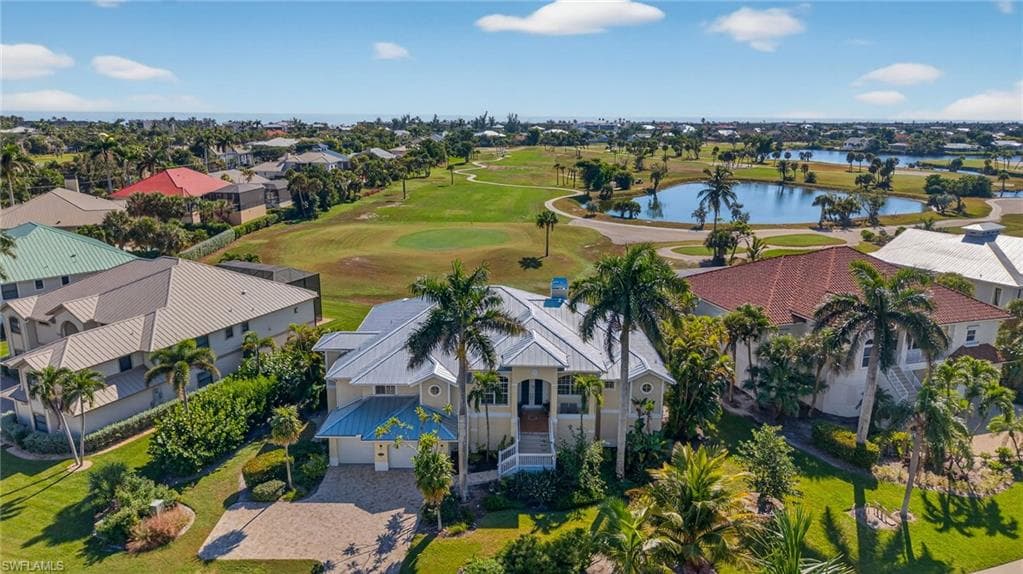 Aerial view of residential area featuring a golf club and a large body of water