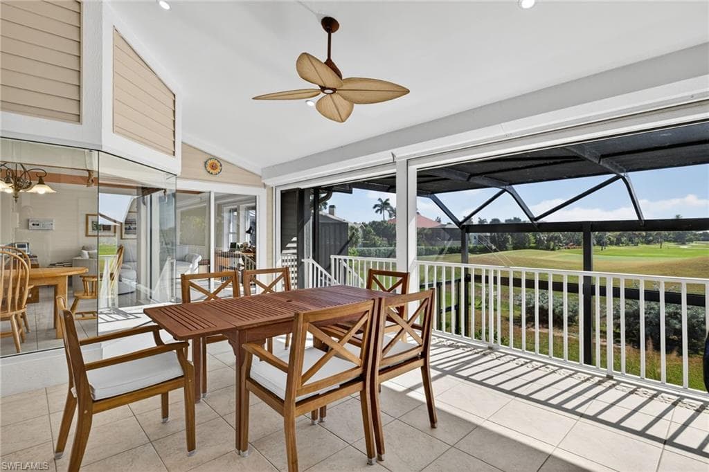 Sunroom / solarium with lofted ceiling, outdoor dining area, view of golf course, and ceiling fan