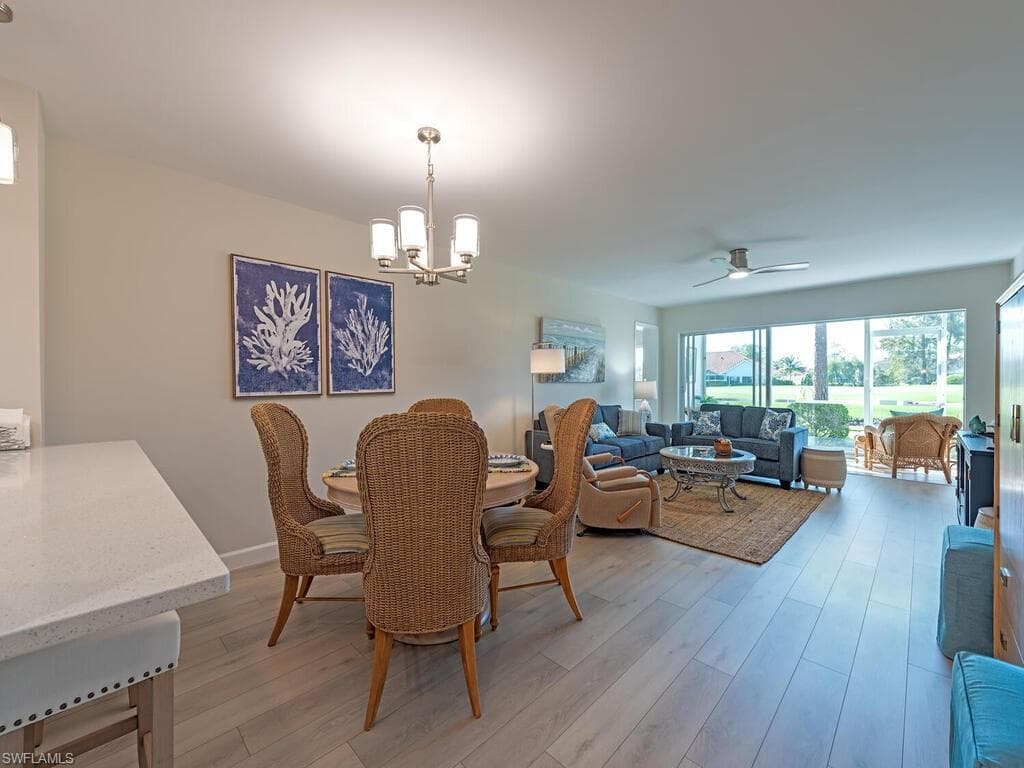 Dining area with ceiling fan, a chandelier, and light wood-style floors