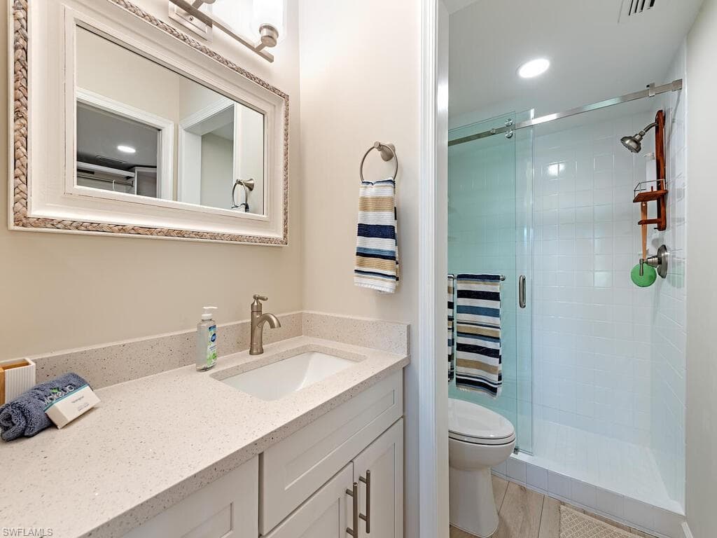 Bathroom featuring vanity, a stall shower, and recessed lighting