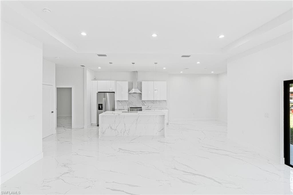 Unfurnished living room with recessed lighting and light marble finish flooring