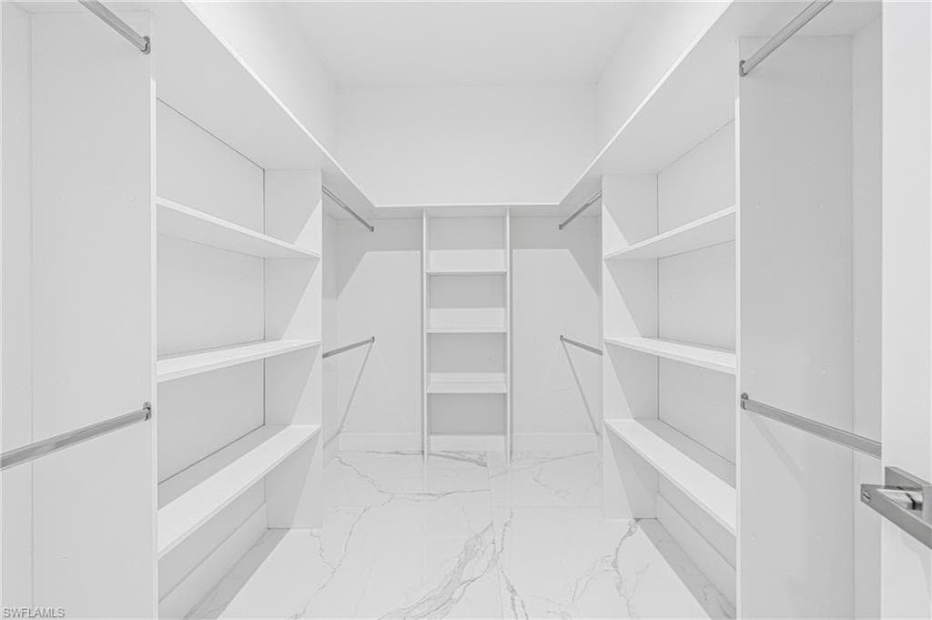 Walk in closet with light marble finish flooring