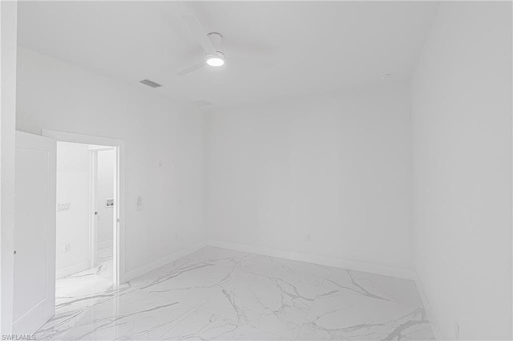 Spare room featuring light marble finish flooring and ceiling fan