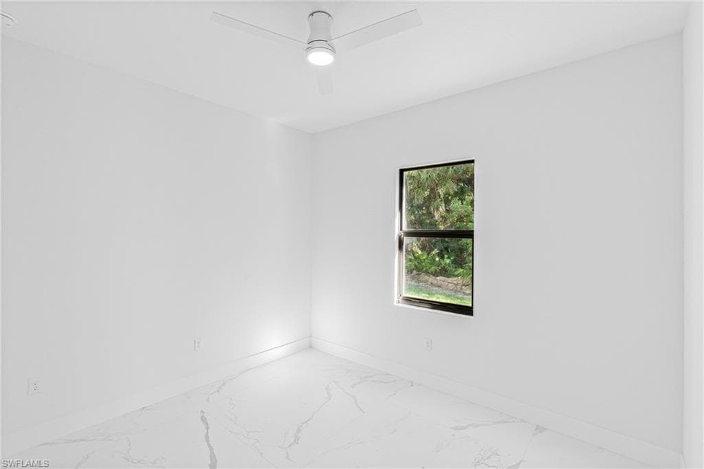 Empty room with marble look tiles and ceiling fan