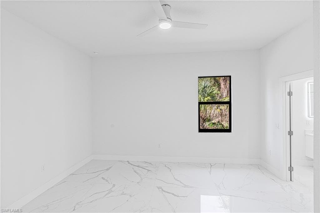 Unfurnished room featuring light marble finish flooring and ceiling fan