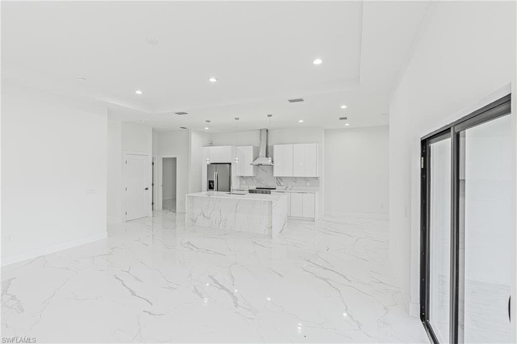 Unfurnished living room with recessed lighting and light marble finish floors