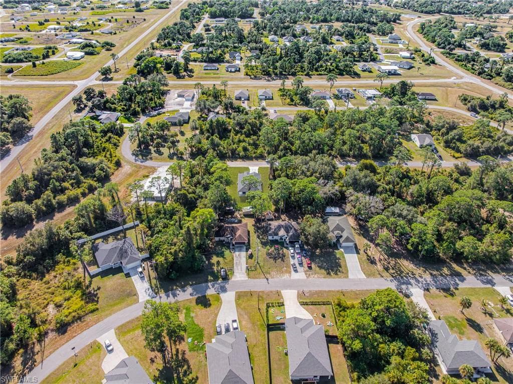 Aerial view of property and surrounding area featuring nearby suburban area