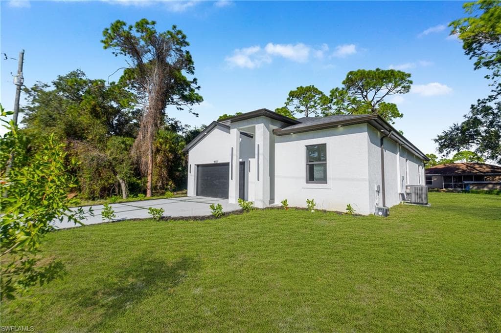 Rear view of house featuring a yard and stucco siding