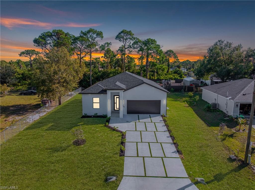 View of front of property with driveway, stucco siding, and a garage