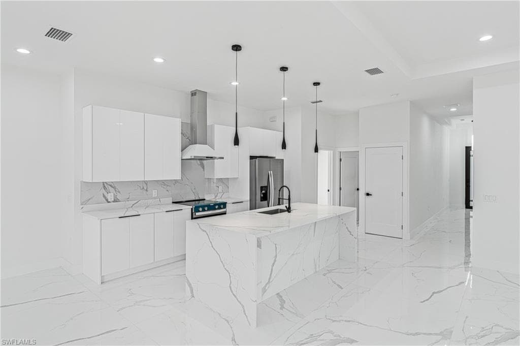 Kitchen featuring decorative light fixtures, white cabinetry, exhaust hood, modern cabinets, and stainless steel appliances
