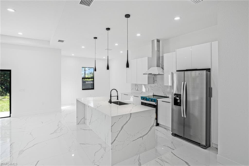 Kitchen featuring stainless steel appliances, light marble finish flooring, wall chimney range hood, modern cabinets, and recessed lighting