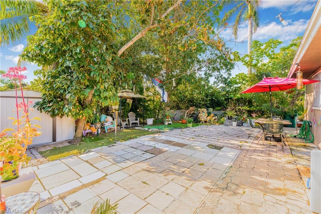 Fenced backyard with a patio area, a storage unit, and outdoor dining space