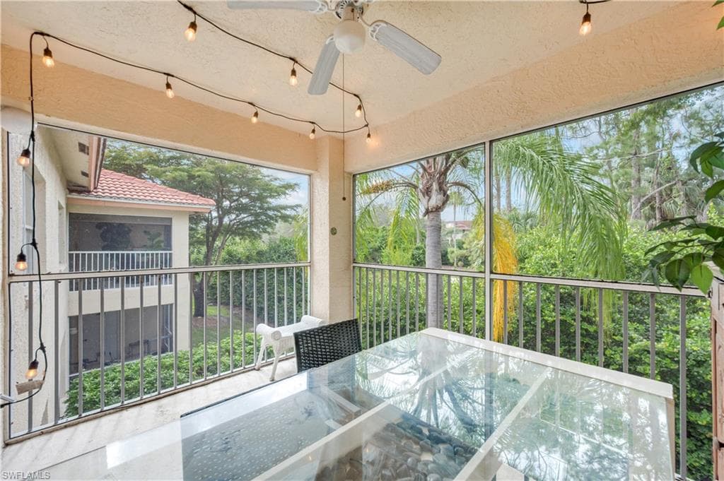 Unfurnished sunroom with a ceiling fan and outdoor dining area