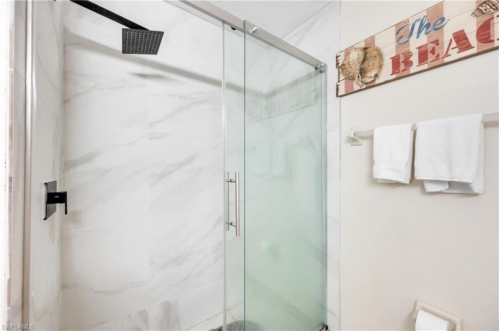 Full bath featuring a marble finish shower