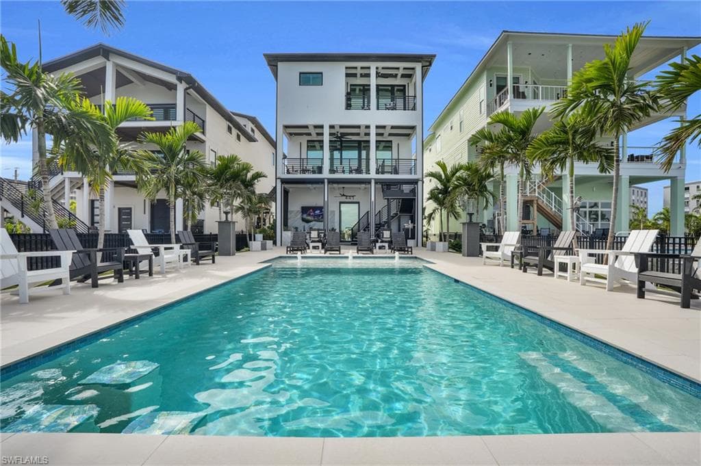 Swimming pool with stairs, a patio area, and a balcony - Virtually Edited Image