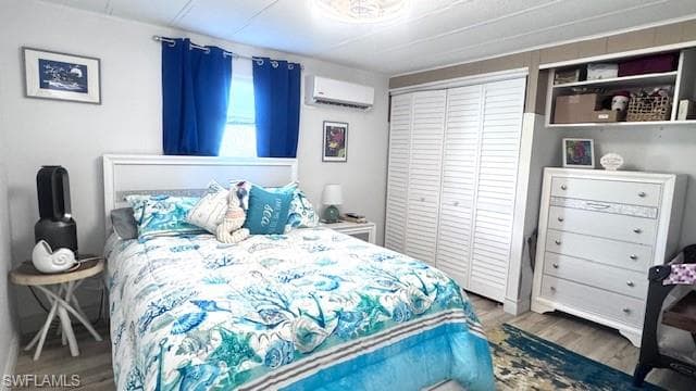 Guest Bedroom featuring wood finished floors, a closet, and an AC wall unit
