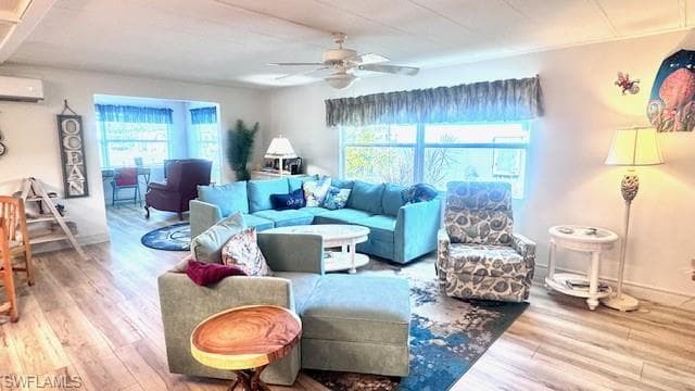 Living room featuring wood finished floors, plenty of natural light, ceiling fan, and a wall mounted AC