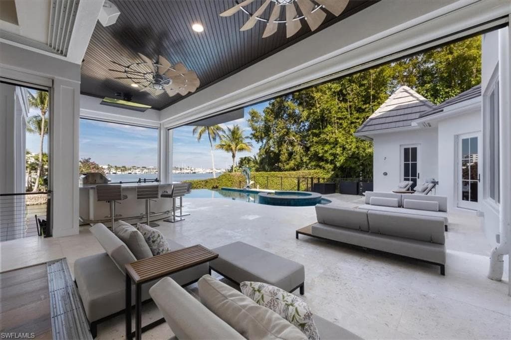 View of patio with an outdoor hangout area, ceiling fan, a water view, and a pool with connected hot tub