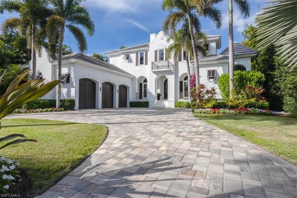 Mediterranean / spanish-style home featuring decorative driveway, a front lawn, stucco siding, a balcony, and a garage
