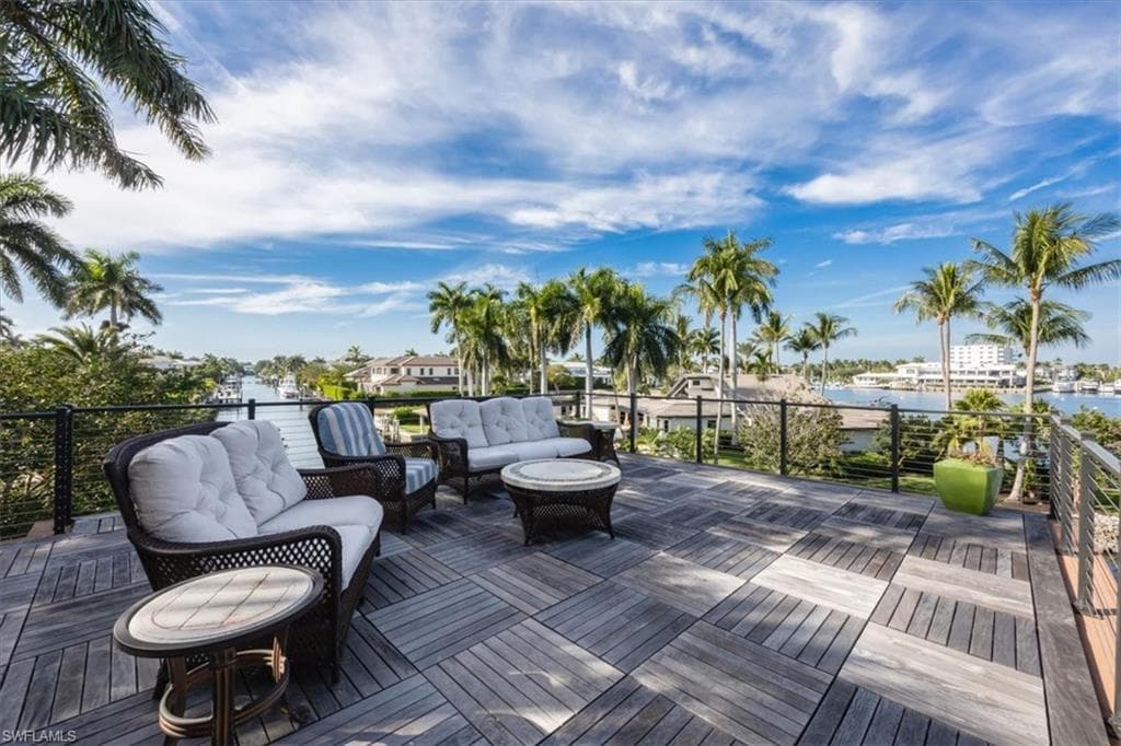 Wooden terrace featuring a water view and an outdoor hangout area