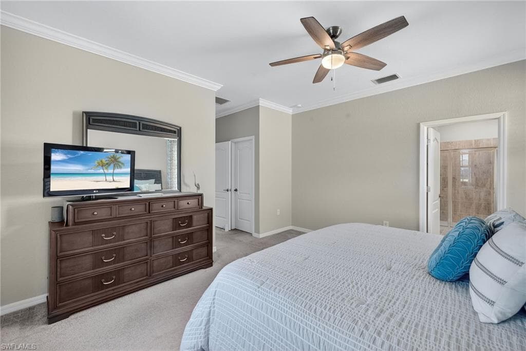 Bedroom featuring crown molding, ceiling fan, light colored carpet, and connected bathroom