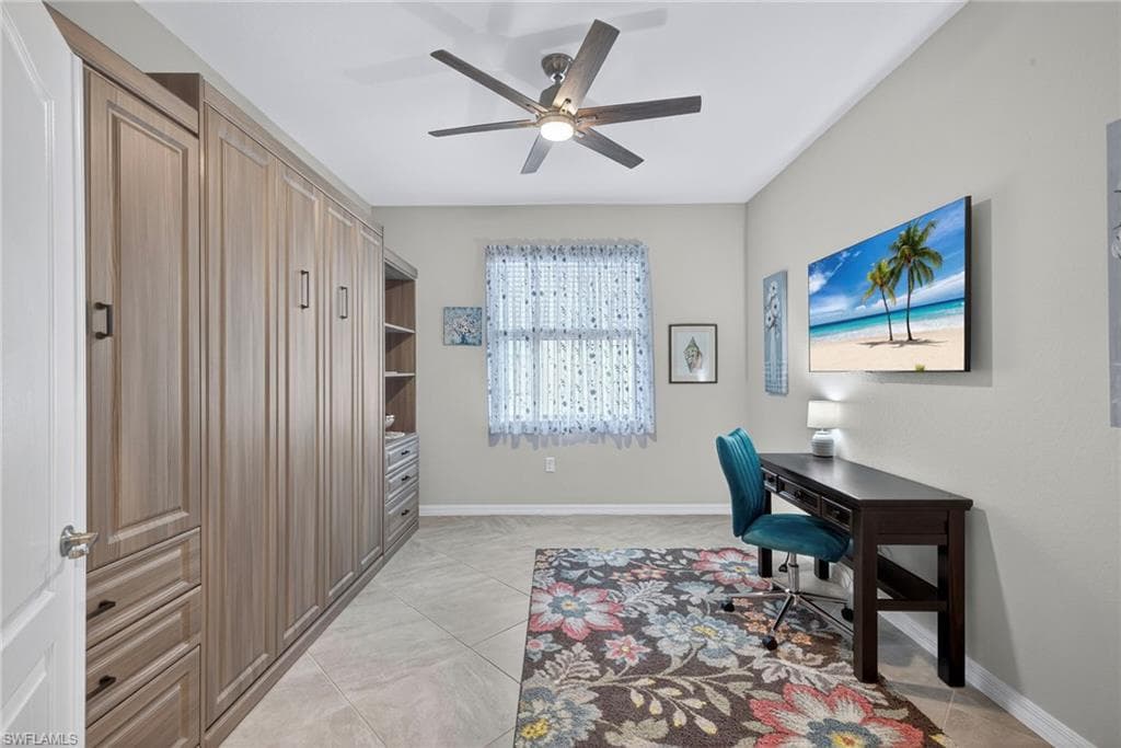 Office space with baseboards and a ceiling fan