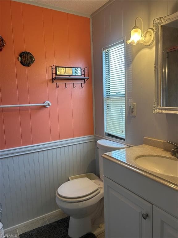 Bathroom featuring a decorative wall, wooden walls, and vanity