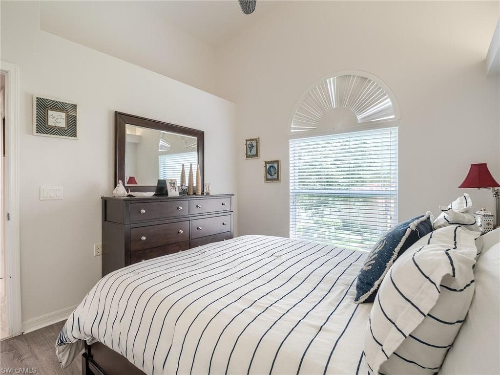 Bedroom with wood finished floors and baseboards