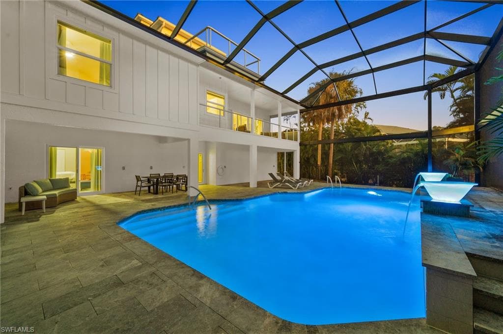 Pool at dusk featuring an outdoor pool, a two story re-inforced no-see um screened pool enclosure!!