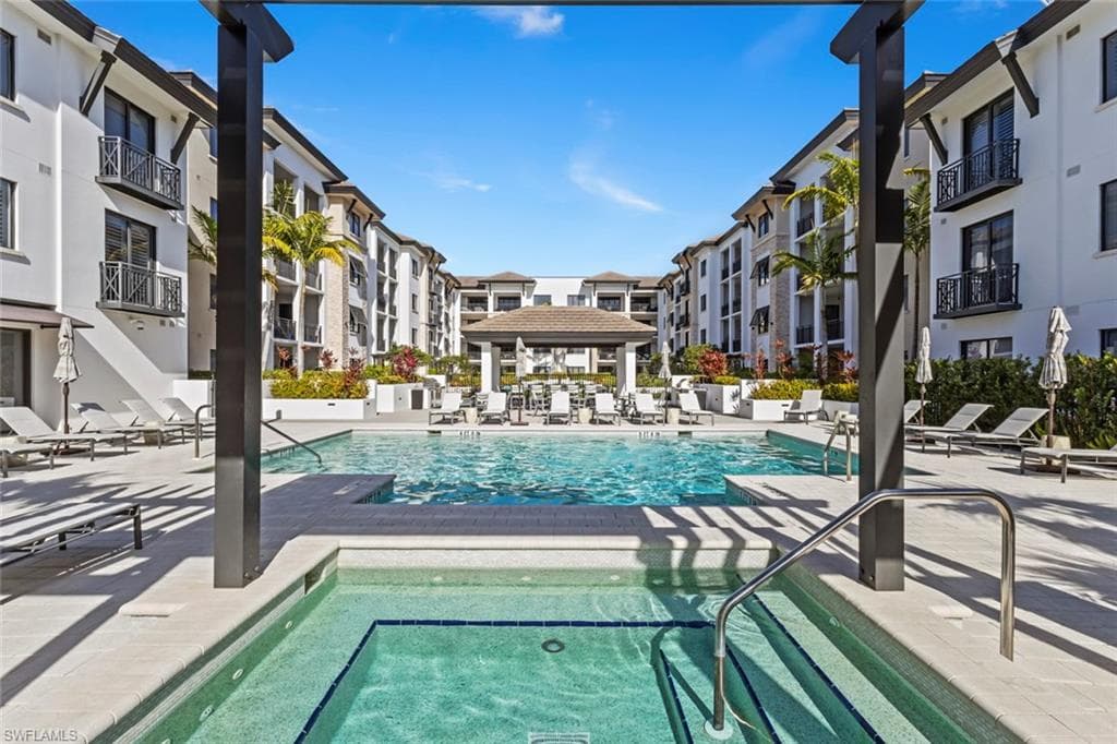 Community pool featuring a patio, a gazebo, and a hot tub