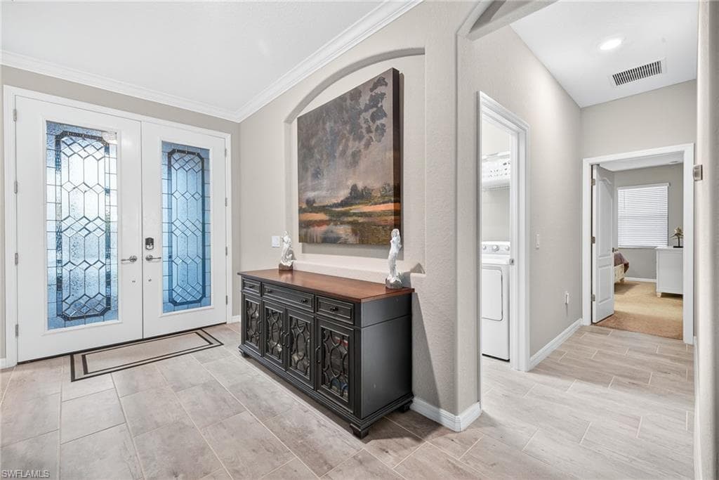 Entryway featuring french doors, washer / dryer, and healthy amount of natural light
