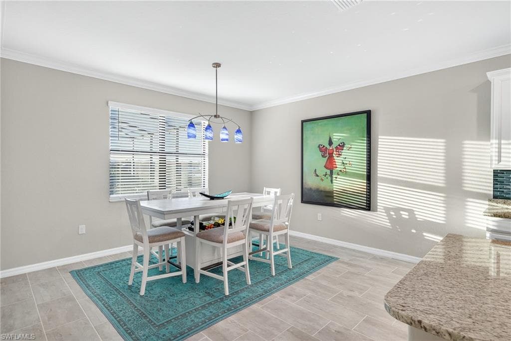 Dining room with baseboards and crown molding